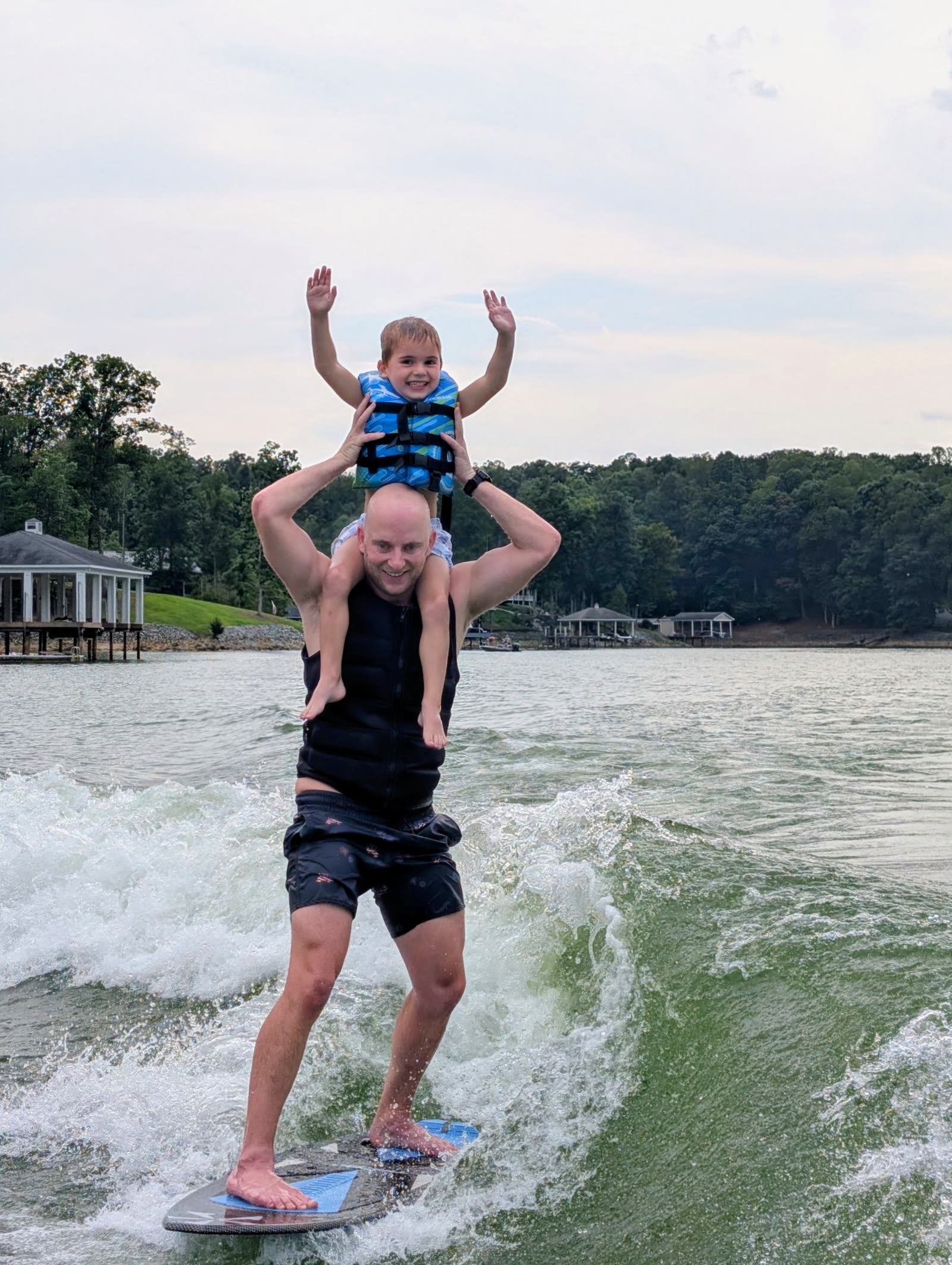 Dash wake surfing with his son on his shoulders